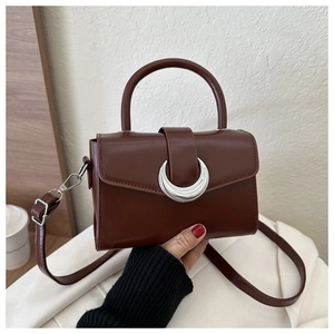 Detail of a vintage dark brown leather bag with a large silver crescent moon buckle