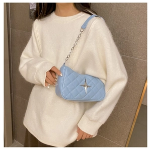 Detail of light blue quilted crossbody bag with silver star buckle and chain strap