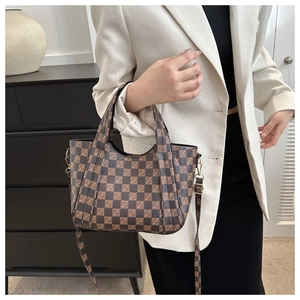 Detailed view of checkered crossbody bucket bag with adjustable strap and sturdy handles