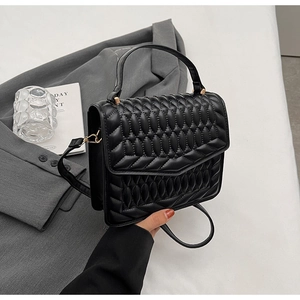 Detail van de zwarte gewatteerde PU-leren crossbodytas met handvat en fijne textuur