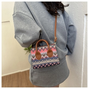 Close-up of bohemian woven crossbody bag with geometric patterns and leather handles