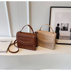 Gewatteerde crossbodytassen in donkerbruin en beige op een minimalistisch display