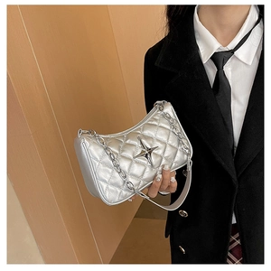 Detailed view of silver quilted crossbody bag with metal star buckle and chain strap