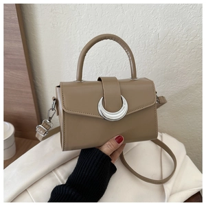 Detail of khaki leather crossbody bag with silver half-moon buckle and top handle