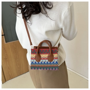 Detailed close-up of a colorful ethnic woven mini tote bag with brown faux leather straps