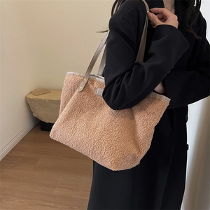 Chic apricot plush tote bag with leather straps and metal studs, shown on a wool coat