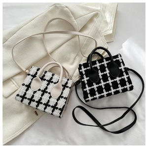 Detail of tweed mini tote bag with leather strap and classic plaid texture