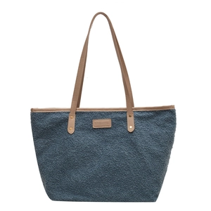Fuzzy grey-blue faux fur tote bag with brown leather handles and fashion logo