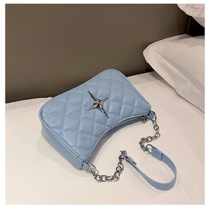 Quilted light blue hobo bag with silver star ornament and chain strap on bed