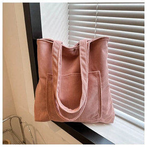 Détail du sac fourre-tout en velours rose avec grande poche avant et bouton magnétique
