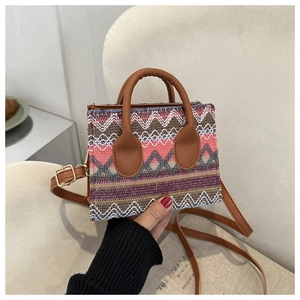 Close-up of colorful ethnic woven texture and leather handle on a small square crossbody bag