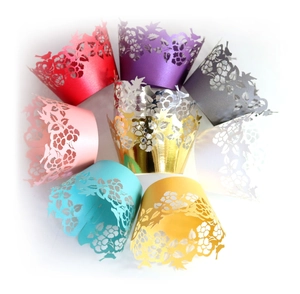 Laser-cut cupcake liners set with floral and bird patterns in multiple vibrant colors