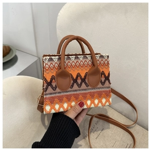 Detail of ethnic woven pattern and brown synthetic leather handles on the crossbody bag