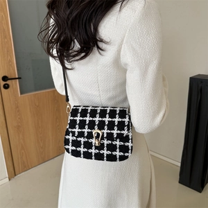 Elegante schwarz-weiße karierte Tweed-Umhängetasche mit goldener Schnalle an Model
