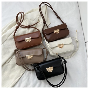 Flat lay of vintage crossbody bags in five colors with triangle metal buckle detail