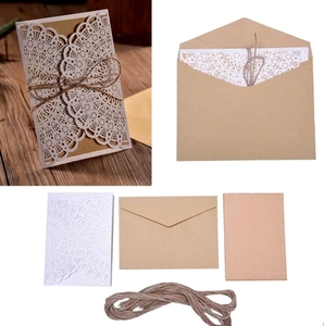 Close-up of laser-cut lace invitation set with kraft paper inserts and jute twine ties
