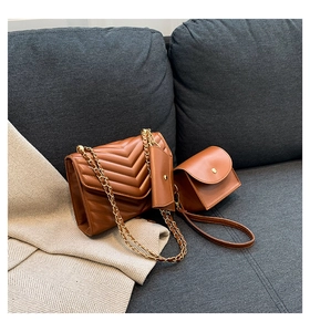Three-piece brown quilted PU leather bag set with gold chain strap on a textured sofa