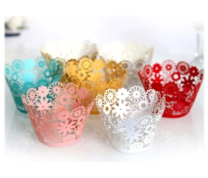 Laser-cut floral cupcake wrappers in various colors including gold, pink, and white