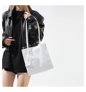 Detail of white lychee textured tote bag featuring a matching small pouch with gold snap