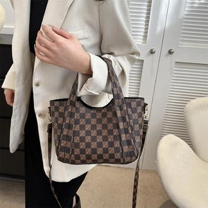 Vintage brown checkered tote bag with adjustable strap shown on a model in urban style