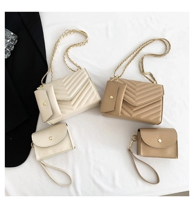 Close-up of V-quilted chain bags in beige and brown with elegant gold hardware detail