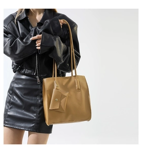 Chic mustard yellow leather tote with a matching mini pouch shown on a fashion model