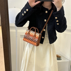 Ethnic woven crossbody bag with orange geometric patterns and brown leather straps