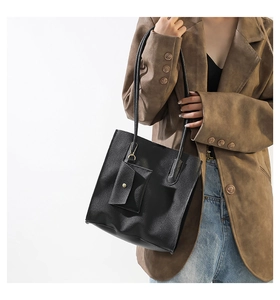 Detail of black textured felt tote bag with a small matching coin purse on a model