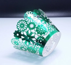 Metallic green laser-cut floral cupcake wrappers with reflective daisy pattern decor