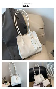 Detailed view of a white pebbled leather tote bag with a matching mini coin purse chain