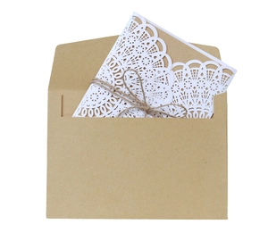 Detail of laser-cut white lace invitation with kraft paper card and hemp rope bow