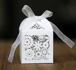 Détail des motifs floraux découpés au laser et ruban d'organza sur boîte de mariage