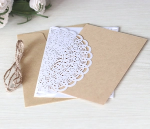 Detail of laser-cut lace paper, rustic kraft envelope and natural twine for invitations