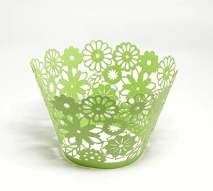 Detailed laser-cut floral pattern on a light green cupcake wrapper for party decor
