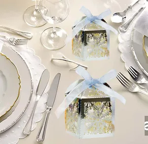 Detailed laser-cut silver snowflake gift box with a blue ribbon on an elegant table