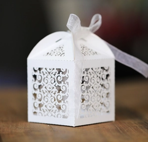 Détail macro du motif de vigne découpé au laser et ruban en organza sur la boîte cadeau