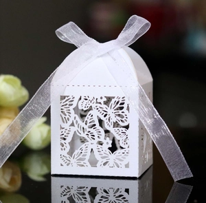 Detailed laser-cut butterfly gift box with white organza ribbon on reflective surface