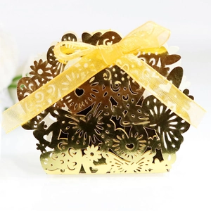 Elegant hollow laser-cut gold wedding favor box with heart patterns and yellow ribbon