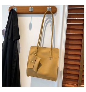 Close-up of mustard yellow leather tote with textured finish and matching mini pouch