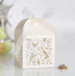 Detail of white laser-cut butterfly candy box with elegant chiffon ribbon bow decor
