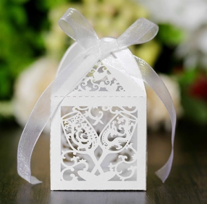 Macro detail of laser-cut white hollow candy box with ribbon for wedding celebrations