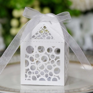 Macro detail of white laser-cut hollow paper candy box with elegant organza ribbon ties