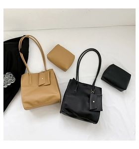 Macro view of brown and black pebbled leather tote bags with matching accessory pouches