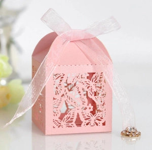 Pink laser-cut wedding favor box with butterfly patterns and ribbon with jewel detail