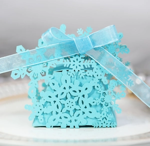 Close-up of light blue laser-cut snowflake gift box with elegant matching ribbon bow
