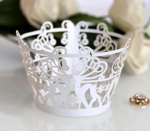 Macro shot of laser-cut white cupcake wrapper with reindeer and snowflake patterns