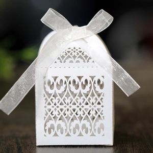 Laser cut white wedding candy gift box with intricate floral pattern and white silk ribbon