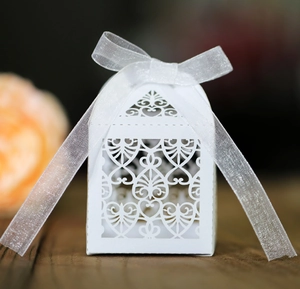 Λεπτομέρεια λευκού κουτιού γάμου laser-cut με σχέδια καρδιάς και κορδέλα οργάντζας