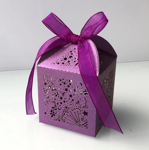 Detail of purple laser-cut candy box featuring hollow star patterns and a chiffon ribbon bow
