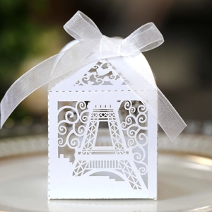 Close-up of white Eiffel Tower laser-cut favor box with delicate white ribbon bow